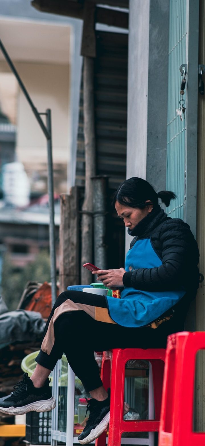 斗罗大陆小说 App 主界面手机实拍，深色阅读界面上排布着章节目录与武魂检索入口，屏幕映出柔和翠绿光晕